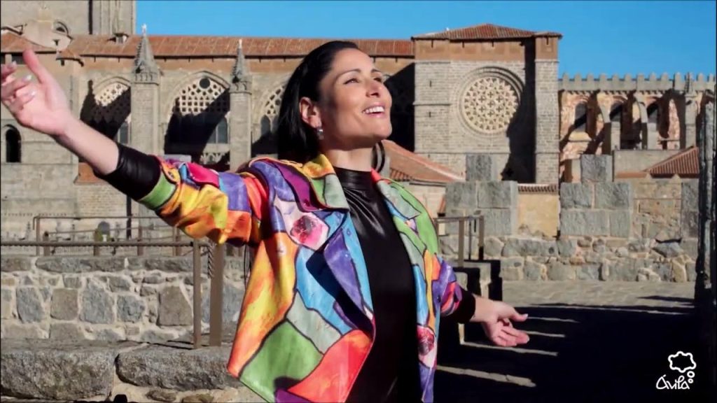 La música es capaz de hacer viajar con los ojos cerrados a cualquier punto del mundo. Además, hay lugares que respiran música. Este es el caso de la nueva campaña turística de Ávila patrocinada por la hipnótica voz de Rosa López. Se trata de una canción llena de vida que invita al espectador a comerse las calles de Ávila. Además, tiene un tono muy especial que incluso evoca a un tono teatral. No cabe duda de que una vez más, la voz de Rosa López vuelve a hacer magia con su espectacular voz. https://www.youtube.com/watch?v=LbOoTCc_P9Y